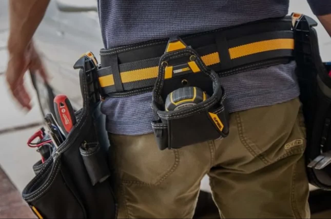 Professional tradesperson with tool belt equipped with renovation tools ready for bathroom installation work