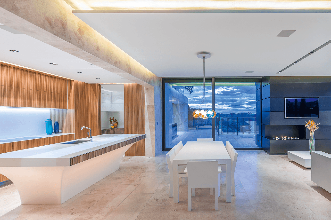 High-end modern kitchen with travertine flooring and sculptural island